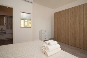 Un dormitorio con una cama, un aparador, un espejo y un armario.