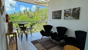 A modern living room with a balcony, black furniture, and artwork on the wall. - Hercules Beach Paradise (Maragogi)