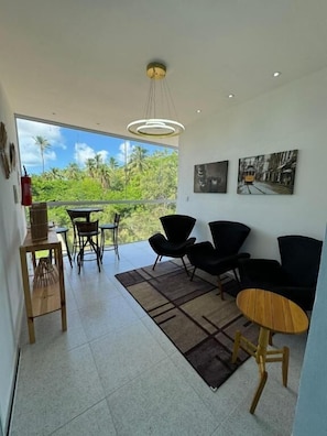 A modern living room with a balcony, black furniture, and artwork on the wall. - Hercules Beach Paradise (Maragogi)