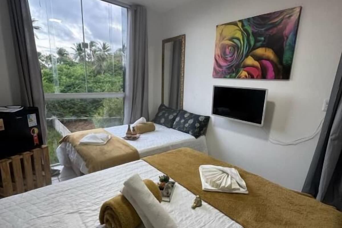 Une chambre d’hôtel avec deux lits, une télévision et un tableau au mur.