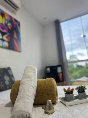 A bed with a rolled white towel, a brown towel, and two small potted plants on a tray. - Hercules Beach Paradise (Maragogi)