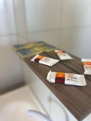 Superficie de madera con varios paquetes pequeños, posiblemente con alimentos, en una habitación con pared de azulejos.