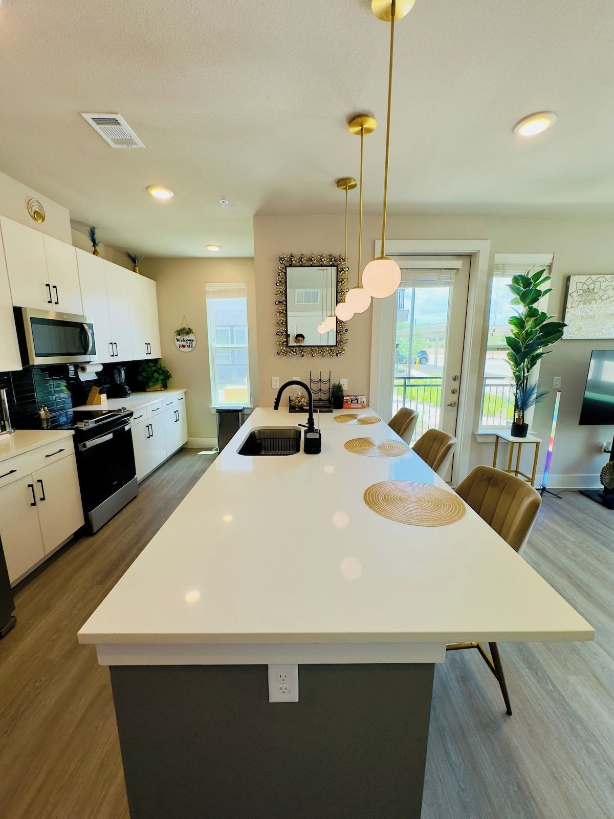 A modern kitchen with a central island, stainless steel appliances, and pendant lighting.