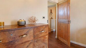 Un armari de fusta amb calaixos, un radiador i una porta de fusta en un passadís.
