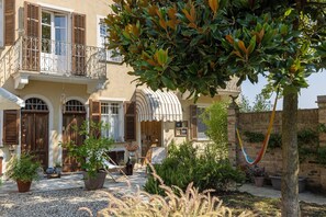 Ein traditionelles Gebäude mit Balkon, Blumentöpfen und einer Hängematte.