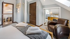 A modern bedroom with a large bed, a wooden ceiling, a glass door leading to a balcony, and a brown leather chair.