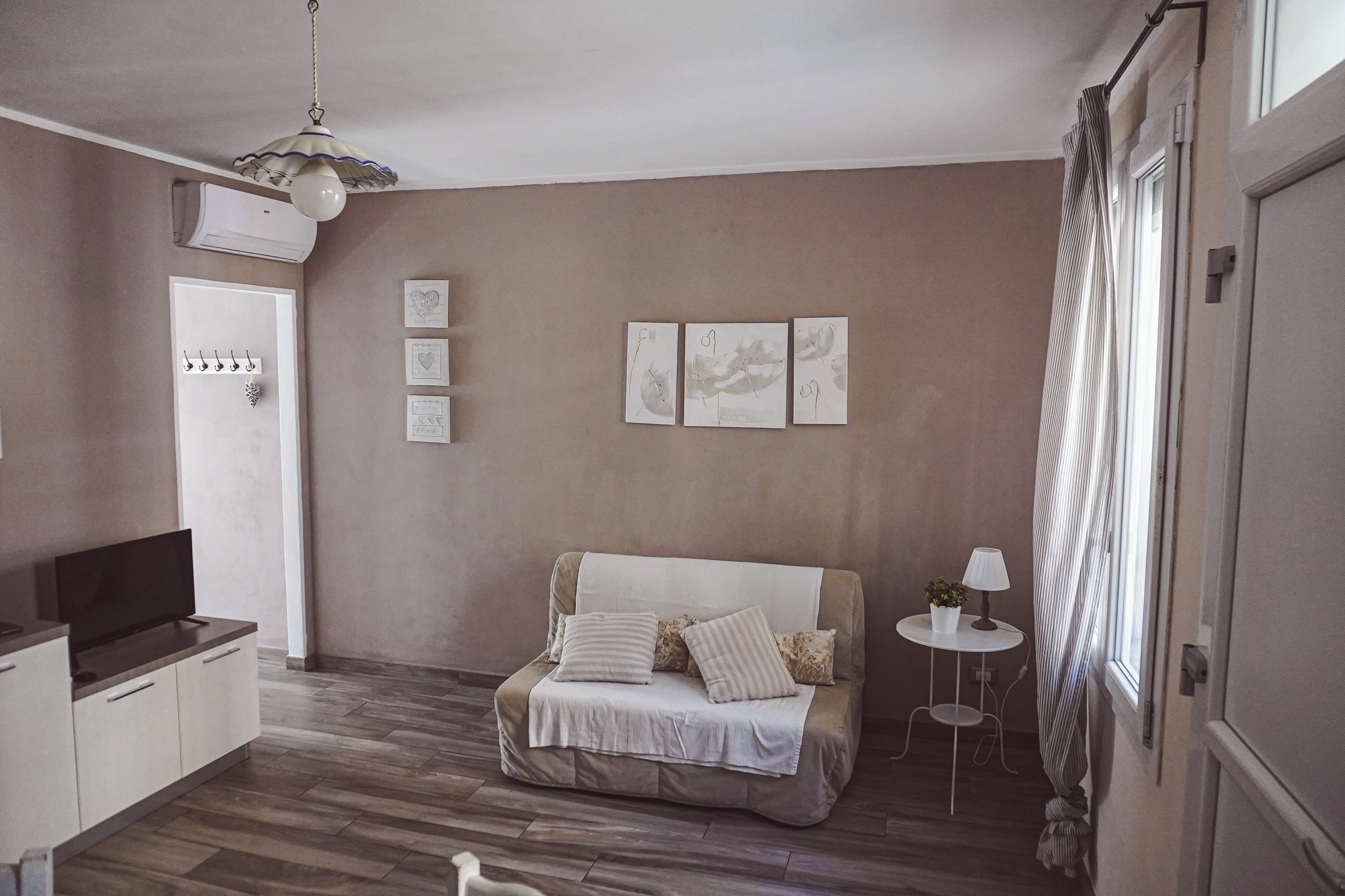 Un dormitorio con cama, mesita de noche, lámpara y decoración en la pared.