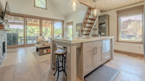 A spacious kitchen with a large island, wooden ceiling, and a view of the outdoors. - Cottage on the 10th Tee Beautiful Stay for 7 w/ Hot Tub & Fire Pit (Eureka)