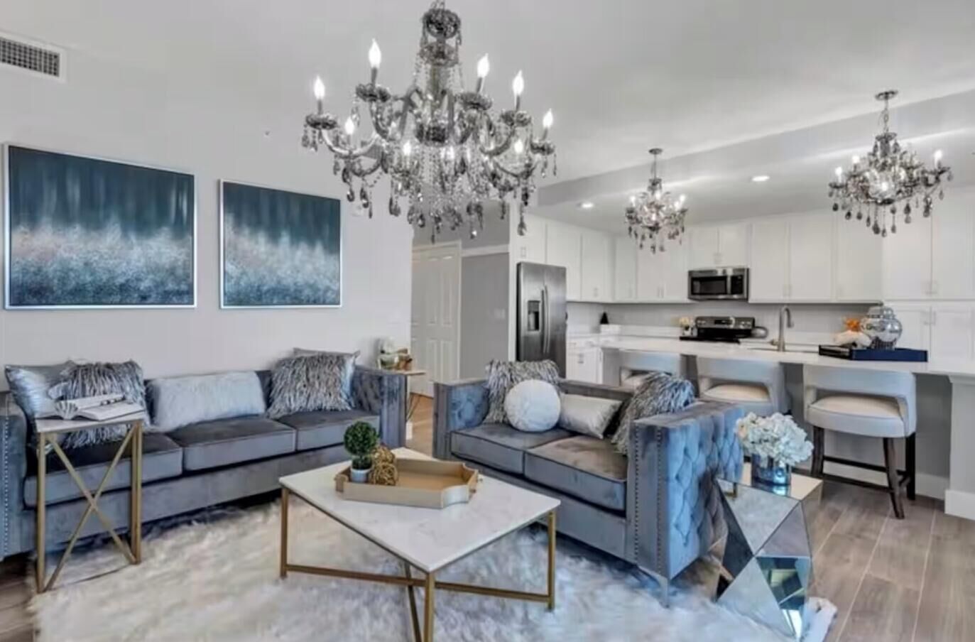 Ein modernes Wohnzimmer mit Sofa, Couchtisch und einer Kronleuchter.