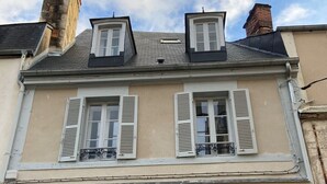 A two-story building with a beige facade, white shutters, and a dormer window. - Love Room downtown with Jacuzzi (Bourges)