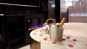 Ein luxuriöses Ambiente mit einem Marmortisch, einem Champagnerkübel und einem Kamin mit blauem Feuer.