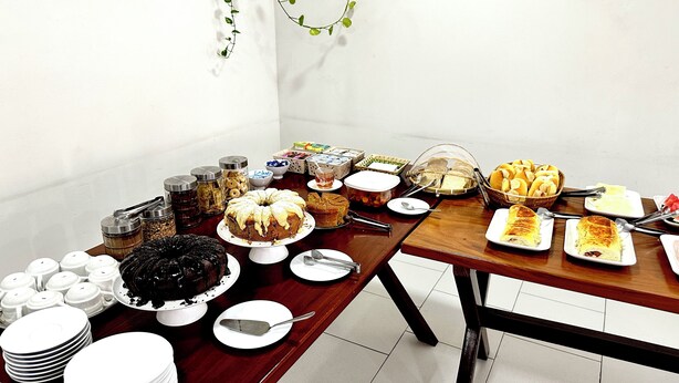 A buffet table with various food items and utensils. - Pousada Lagoa Azul (Paraty)