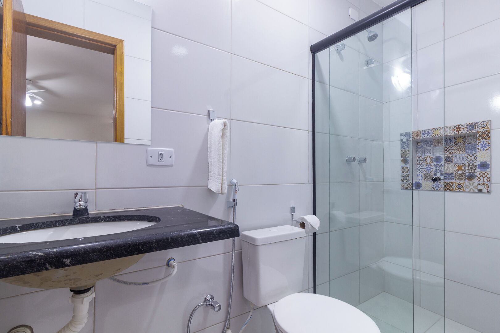 A bathroom with a sink, toilet, and glass shower enclosure.