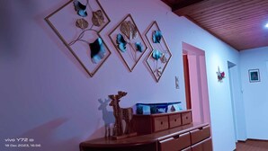 A room with a wooden dresser, a mirror, and wall-mounted decorative items.