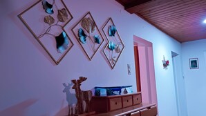 Una habitación con un aparador de madera, un espejo y adornos en la pared.