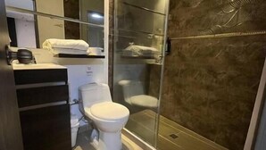 A modern bathroom with a toilet, sink, and shower area. - HOTEL AIRPORT PEREIRA (Pereira)