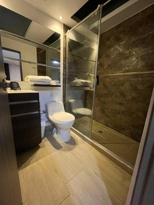 A modern bathroom with a toilet, sink, and shower area. - HOTEL AIRPORT PEREIRA (Pereira)