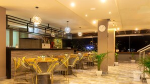 A restaurant with wicker chairs, a bar area, and potted plants. - HOTEL AIRPORT PEREIRA (Pereira)