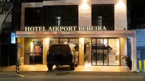 A modern building with the sign "HOTEL AIRPORT PEREIRA" and a parked SUV in front. - HOTEL AIRPORT PEREIRA (Pereira)