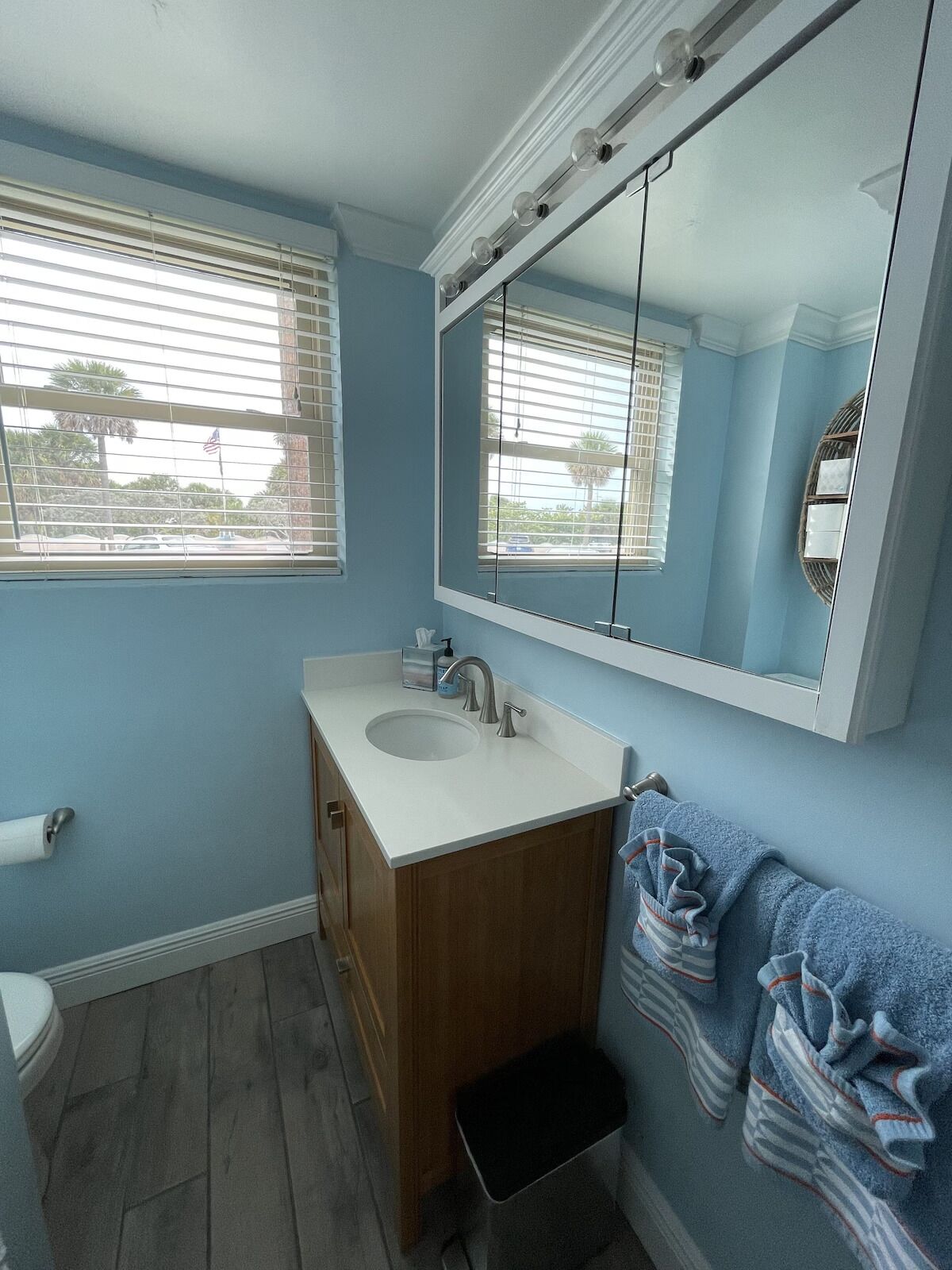 A bathroom with a sink, mirror, and towel rack.