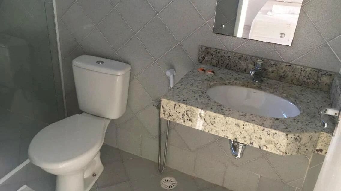 Un baño con inodoro, lavabo y espejo.