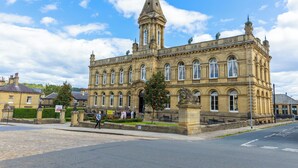 A historic building with a prominent tower and arched windows. - Stylish Saltaire Cottage | Walk to Salts Mill | Parking & Fast WiFi (Saltaire)