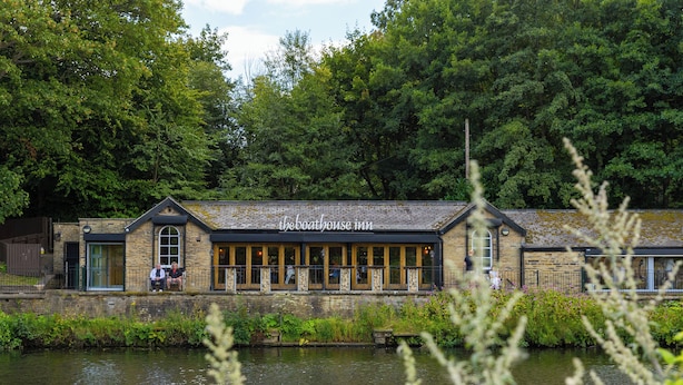A riverside building with a sign reading "theboathouse.co.uk". - Stylish Saltaire Cottage | Walk to Salts Mill | Parking & Fast WiFi (Saltaire)