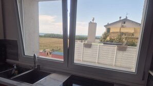 Una cocina con vistas a un edificio y un área cercada.