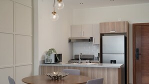 Una cocina moderna con una isla central, electrodomésticos de acero inoxidable y una puerta de madera.