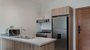 Una cocina moderna con encimera de granito, electrodomésticos de acero inoxidable y armarios de madera.