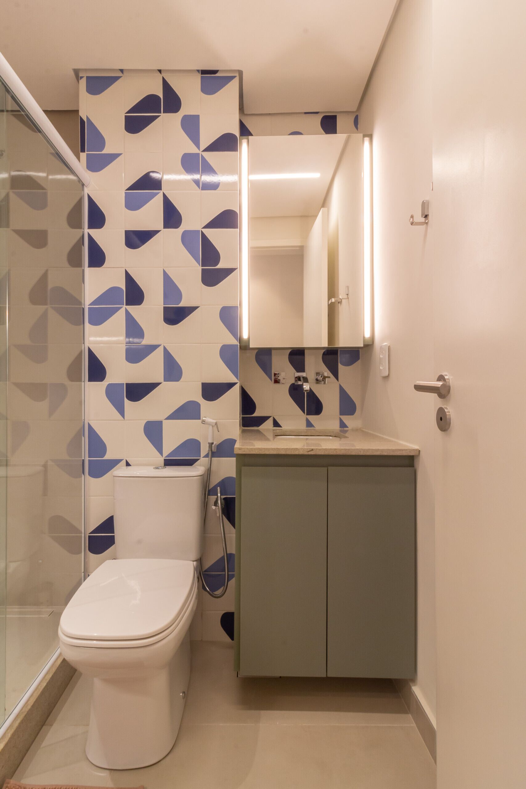 A bathroom with a toilet, a sink, and a mirror.
