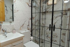 Chuveiro, secador de cabelo, toalhas de banho, papel higiênico