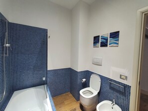 Een douche, een haardroger, een bidet, handdoeken