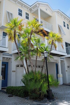 A multi-story building with a balcony, a street lamp, and a cobblestone driveway.