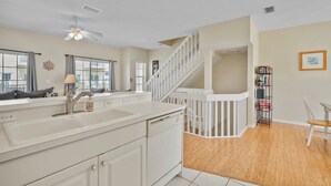 A modern kitchen with a white countertop, a built-in oven, and a white staircase leading to an upper level. - Wonderful townhouse located directly between the beach and the bay.  Watch the sunsets off the balco (BRADENTON BEACH)
