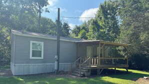 A single-story house with a covered porch and a small deck.