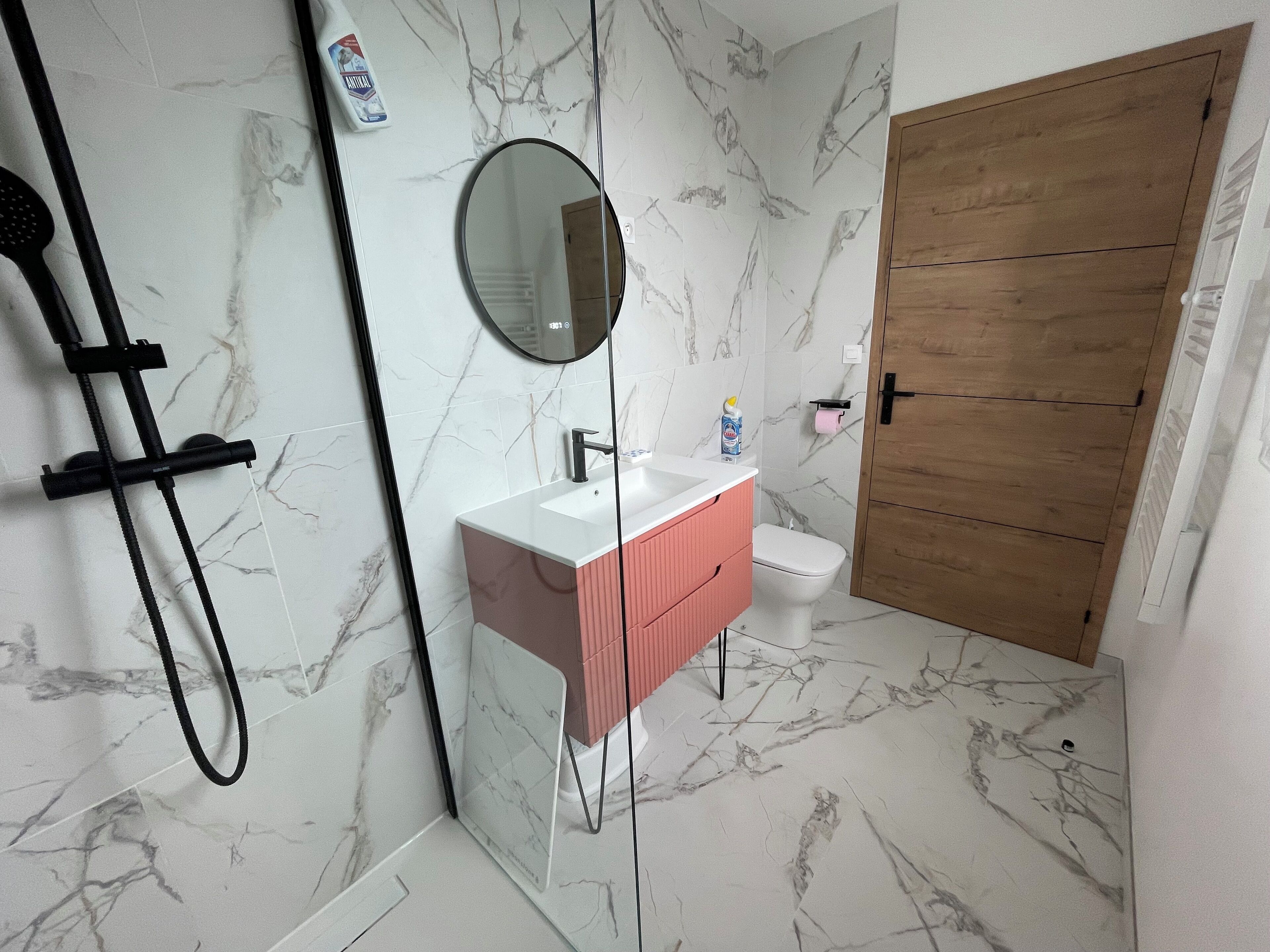 A bathroom with a shower, sink, and toilet.