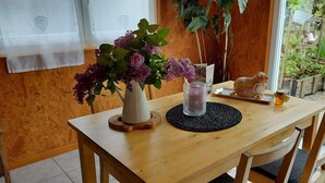 Una mesa de comedor de madera con un jarrón de flores moradas, un candelabro decorativo y una figurita.