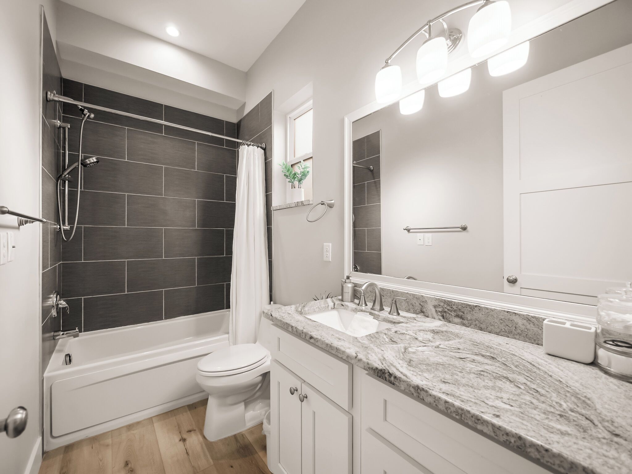 A modern bathroom with a bathtub, toilet, and shower area.