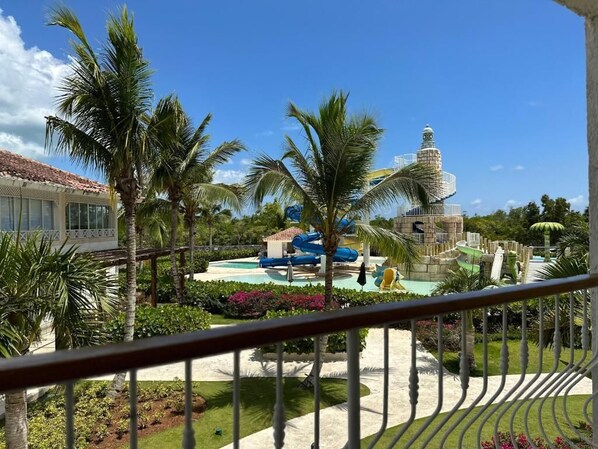A resort with a pool area, palm trees, and a water slide.