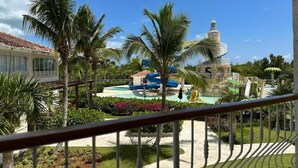 A resort with a pool area, palm trees, and a water slide. - Hotel Palmera Bayahibe - One-Bedroom Villa 2 (República Dominicana)