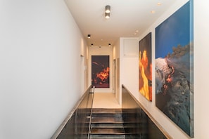 A modern interior with a staircase, a hallway, and two large abstract paintings. - Studio 'Pardo 03' with Wi-Fi and Air Conditioning (Catania)