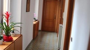A hallway with patterned flooring, wooden doors, and a radiator. - Chez Liviana (Rome)