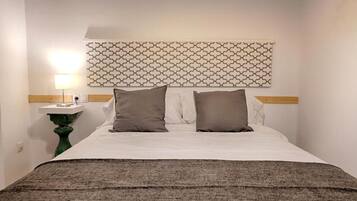 Escritorio, tabla de planchar con plancha, wifi y ropa de cama