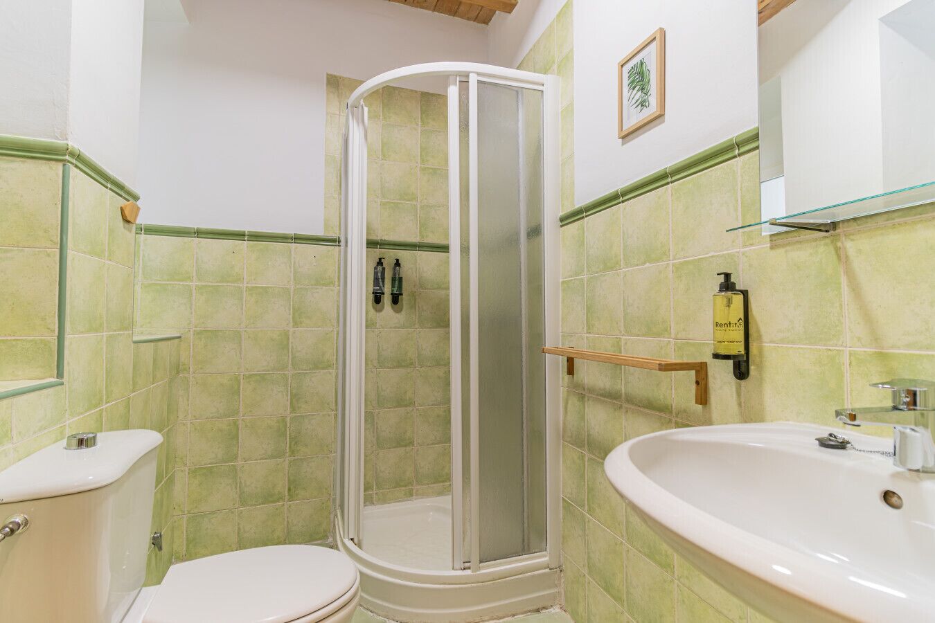 A bathroom with a shower, toilet, and sink.