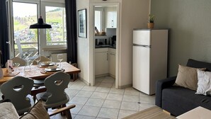 A modern kitchen with a refrigerator, dining table, chairs, and a view of the outside. - Vacation apartment "SchwarzwaldnACHT" - peace & nature in Todtnauberg - Mein SWH (Todtnauberg)