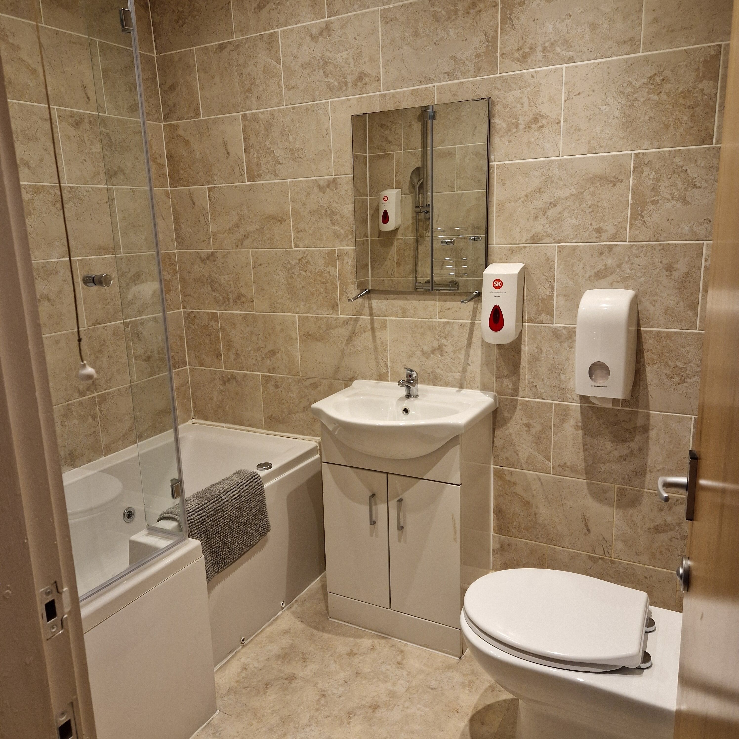 A bathroom with a bathtub, a sink, a toilet, and a glass shower enclosure.