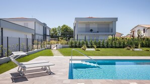 A modern residential area with a swimming pool, a covered patio, and a well-maintained lawn. - Apartment Petra with Pool (Lazise)