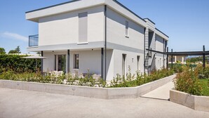 A modern two-story building with a flat roof, large windows, and a balcony. - Apartment Petra with Pool (Lazise)