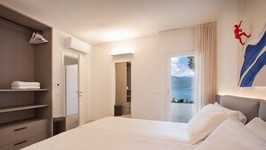 Habitación de hotel con cama, armario, baño y vista al mar.